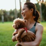 Patelco member Judy F. holds her small dog.