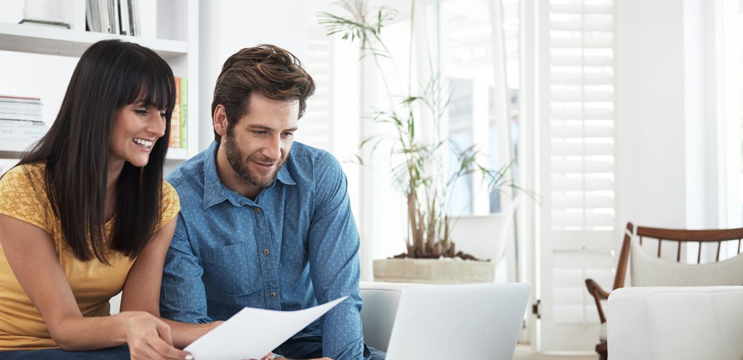 A fashionable Millennial couple reviews their Coverdell Education Savings Account information from Patelco Online.