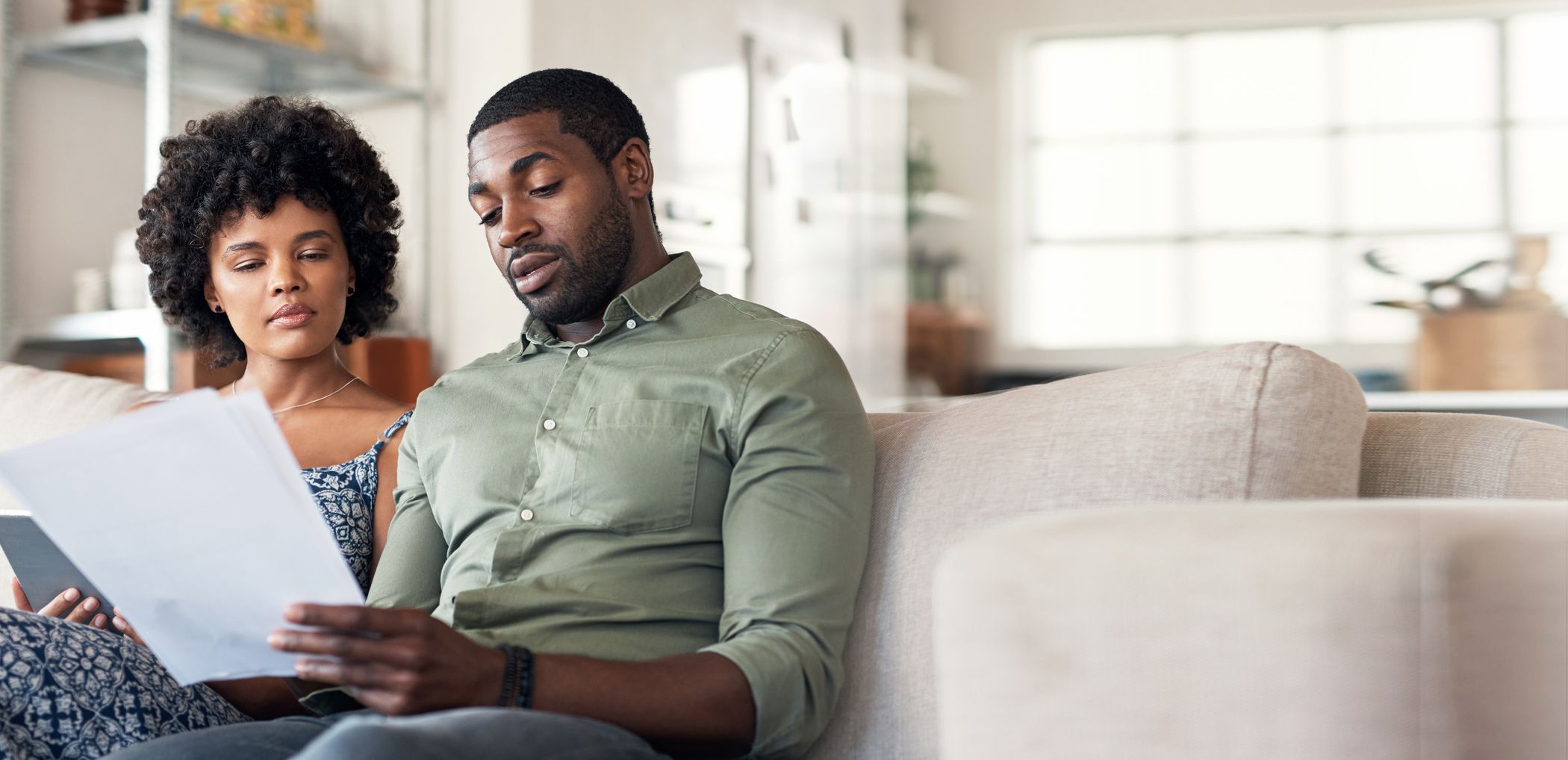 A couple reviews their budget plan from their couch at home.