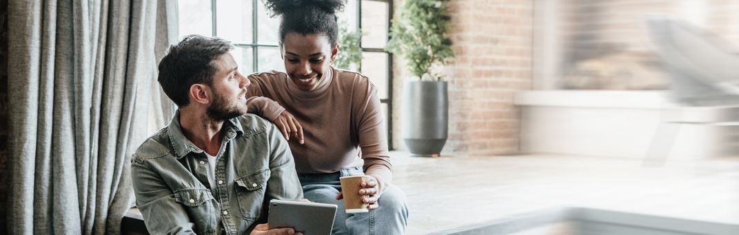 A man a woman review their savings account over coffee.