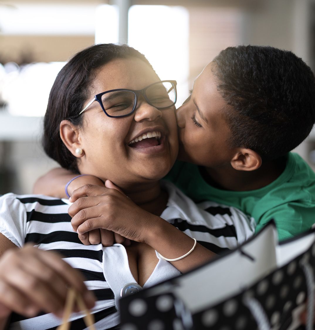 Patelco member Jane gets a kiss on the cheek from her son.