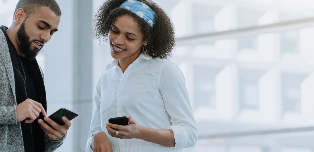 A Millennial shows a friend how to check her accounts on a phone with Patelco Online.