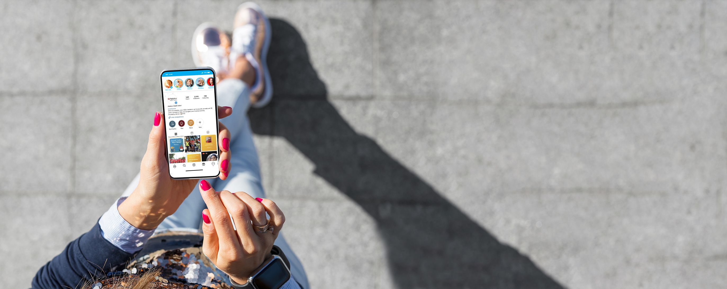 Person holding a phone displaying social media outside